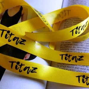 Polyester satin ribbon yellow color with logo. Satin ribbon with printed logo black silver gold.